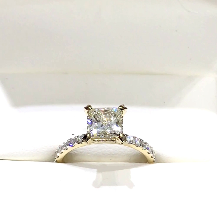 18kt Yellow Gold Engagement Ring with 2 carat lab diamond at the center (Color: E | Clarity: VS1 | Princess Cut) and natural E / VVS grade Setting Diamonds. Solitaire Setting with Pave Set Diamonds on the shank and on the prongs.